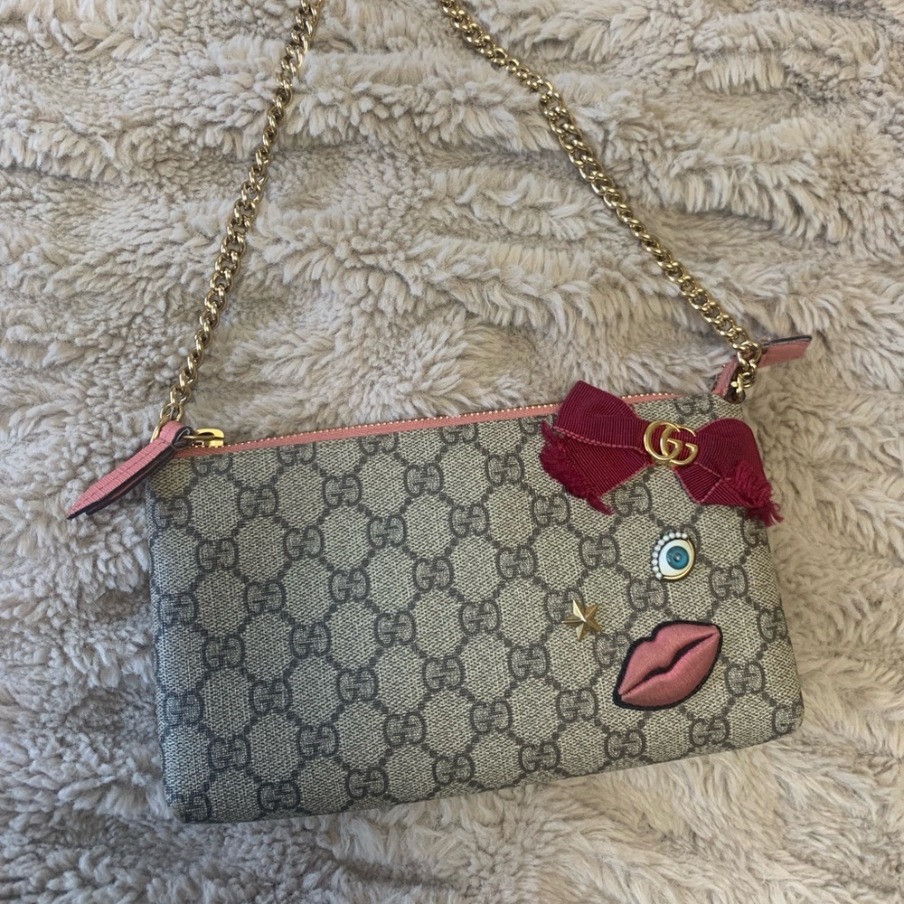 Gucci shoulder bag with Gucci monogram print and red interior.